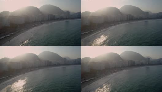 巴西里约热内卢科帕卡巴纳海滩的背光海洋航拍，午后的阳光和群山在背景中高清在线视频素材下载
