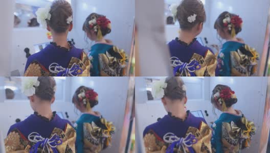 身着Furisode和服的年轻女子在“Purikura”照片贴纸摊上为“Seijin Shiki”成人礼拍照高清在线视频素材下载