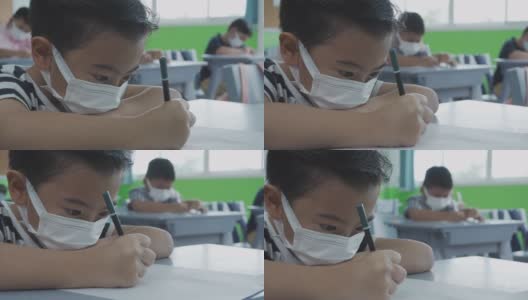 小学生在教室里戴着口罩。高清在线视频素材下载