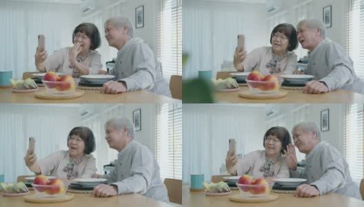 年轻的老年亚洲公民夫妇手持手机自拍视频在线通话在家中公寓的餐桌上老年人用数字技术虚拟谈话会议的概念。高清在线视频素材下载
