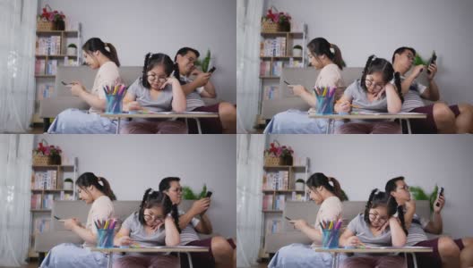 年轻的父母在女儿无聊的时候玩手机高清在线视频素材下载
