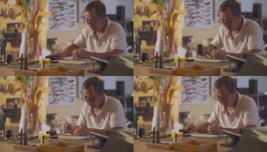 一位亚洲华人老人在他的工作室里制作手工皮革表带高清在线视频素材下载