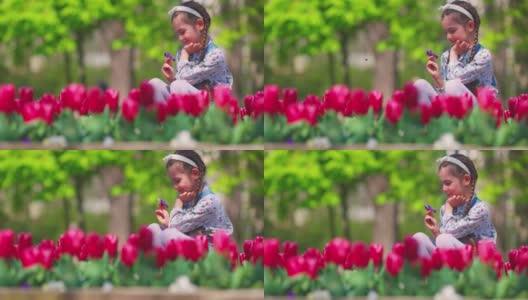 快乐的女孩在城市公园里享受着芳香和美丽的花园。春天的郁金香。高清在线视频素材下载
