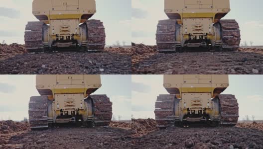 履带式推土机在建筑工地或采石场工作的跟踪镜头。矿山机械搬运粘土，平整砾石路面，用于新建道路。土方，挖掘，在土壤上挖掘。高清在线视频素材下载