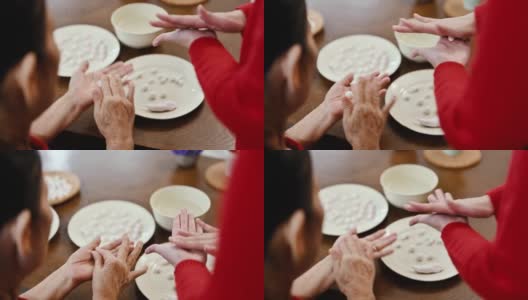 一位亚洲的祖母和她的孙女准备制作汤圆庆祝中国新年高清在线视频素材下载