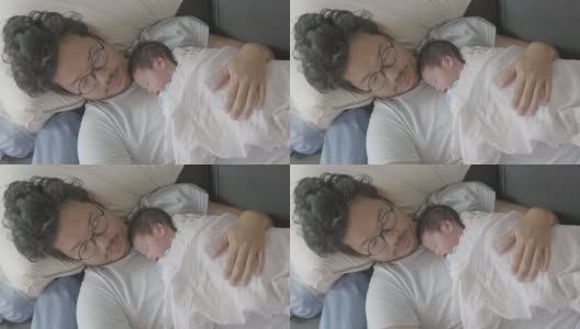 4k幸福疲惫的亚洲父亲和儿子睡在沙发上早上。高清在线视频素材下载