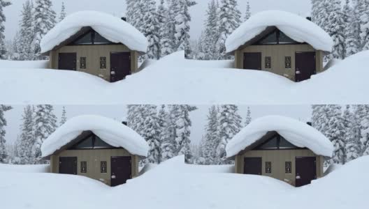 在冬天，树木被雪覆盖，雪花飘落，休息站的洗手间高清在线视频素材下载