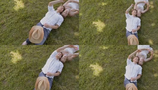 年轻夫妇躺在草地上，吹泡泡高清在线视频素材下载