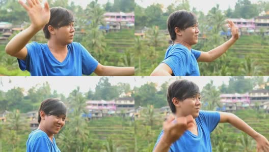 年轻的巴厘男舞者在稻田外练习舞蹈高清在线视频素材下载