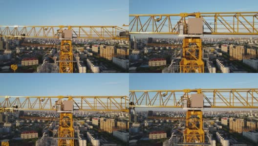 日落时分，无人机镜头移动到建筑工地的吊车塔上高清在线视频素材下载