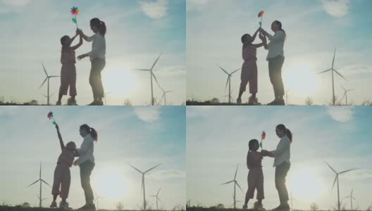 家庭幸福在风力涡轮机农场，慢镜头。高清在线视频素材下载