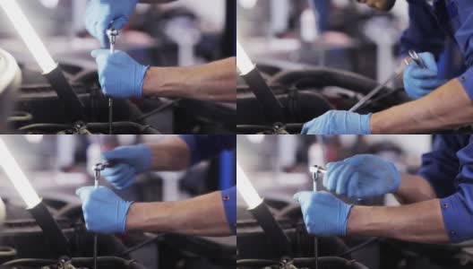 在汽车修理厂用扳手修理汽车的技工高清在线视频素材下载