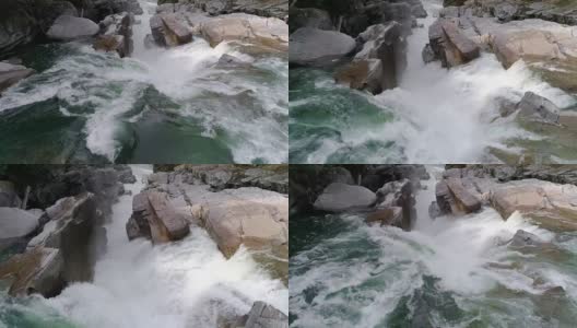 慢动作无人机低飞在绿色的水在瀑布边缘在岩石峡谷高清在线视频素材下载