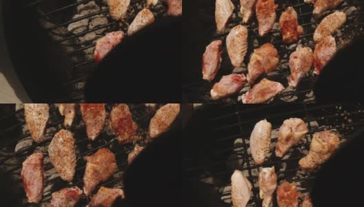 在户外烧烤架上的生鸡翅上直接洒上香草/调味料(从调味料容器的角度看)高清在线视频素材下载