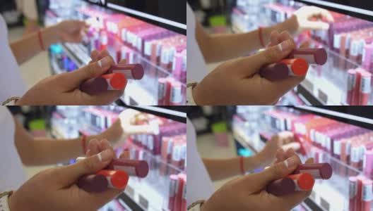 女人在化妆品美容店选择口红。特写镜头。高清在线视频素材下载