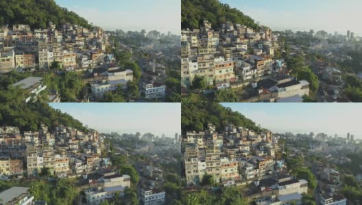 日出在空中飞过森林下的山顶贫民窟，背景是市中心的高楼大厦高清在线视频素材下载