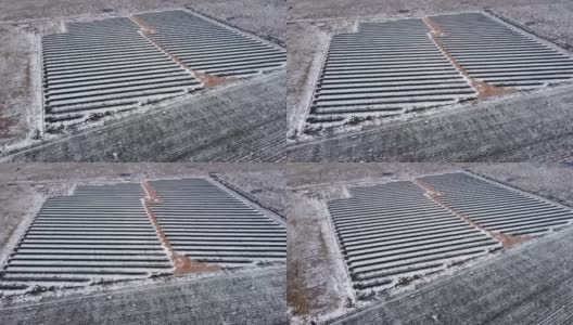 冬季雪地使用光伏元件生产可再生能源的太阳能发电站鸟瞰图高清在线视频素材下载