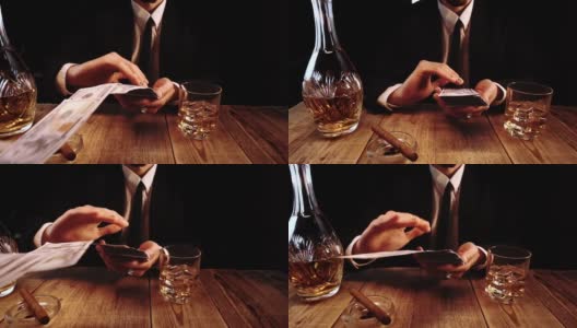 一个穿着黑色服装坐在酒吧里扔钞票的富人的特写镜头高清在线视频素材下载
