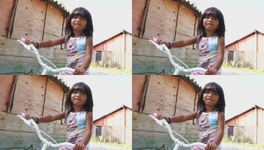 可爱的女孩肖像骑自行车在农村的地方高清在线视频素材下载