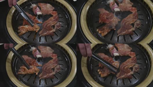韩国烧烤架。人们在餐馆里用韩式烧烤做菜吃。4 k,特写。高清在线视频素材下载