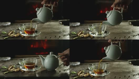 美丽浪漫的草药茶和茶的组合，它被倒在一个古老的木制砧板上，背景是香料和壁炉高清在线视频素材下载