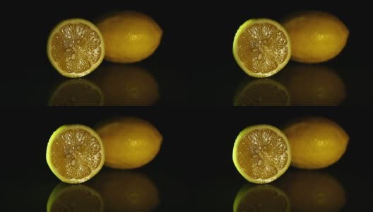 一片柠檬和一个多汁的柠檬放在深色镜子桌上。高清高清在线视频素材下载