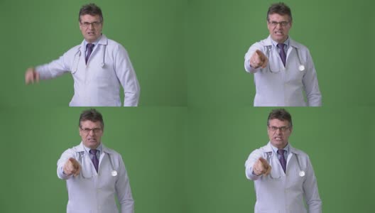 成熟帅气的男医生映衬着绿色的背景高清在线视频素材下载