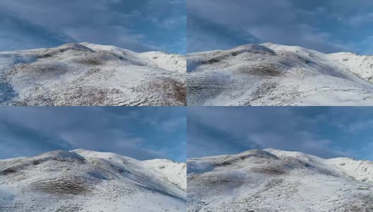 向前鸟瞰冬季雪山山顶在晴朗的日子与云和蓝色的天空。白阿尔卑斯山雪季的缔造者。达到峰值。4k无人机飞行建立镜头高清在线视频素材下载