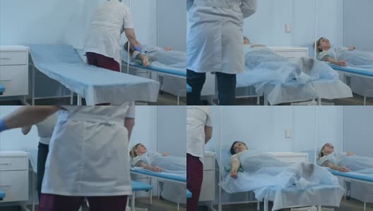 两名女病人躺在医院病房的床上打点滴，由两名医生检查高清在线视频素材下载