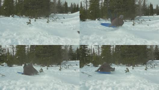 一个年轻人骑着雪橇跳过一座雪山的慢动作镜头。高清在线视频素材下载