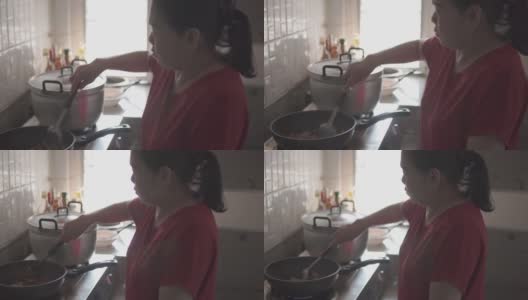 年长的亚洲妇女在家做饭。高清在线视频素材下载