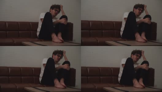 绝望的男人双手抱头坐在沙发上为压力和抑郁的概念哭泣。高清在线视频素材下载