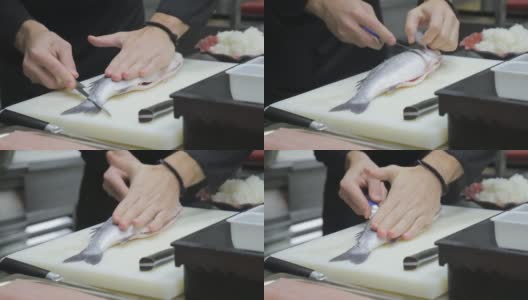 厨师熟练地用鱼刀将鲈鱼切开去骨高清在线视频素材下载