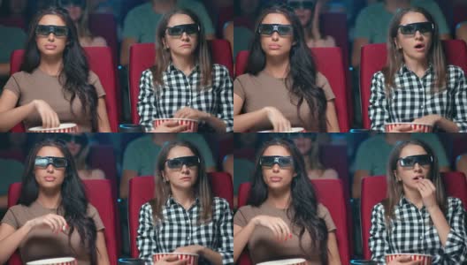两位女性朋友戴着3d眼镜观看电影首映式，一脸震惊的表情坐在前排高清在线视频素材下载