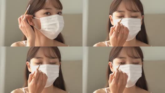 年轻的亚洲女人戴着面具化妆高清在线视频素材下载