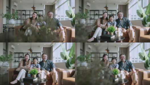 幸福快乐的亚洲家庭父母和儿子儿子一起看电视，在客厅的沙发上度过假期的周末时间。家庭和家庭的概念。高清在线视频素材下载