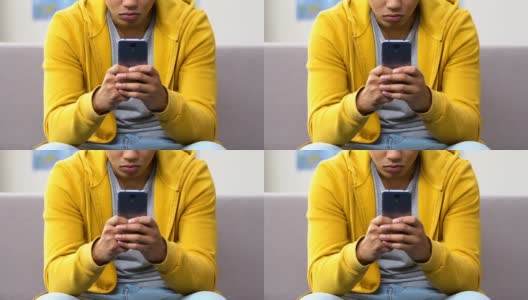 非裔美国男孩在智能手机上快速打字，和朋友在网上聊天高清在线视频素材下载