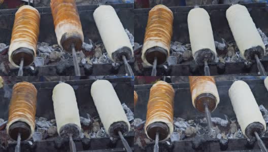 传统的捷克甜品Trdelnik将其放在特制的木串上，放在炙热的炭火上。高清在线视频素材下载