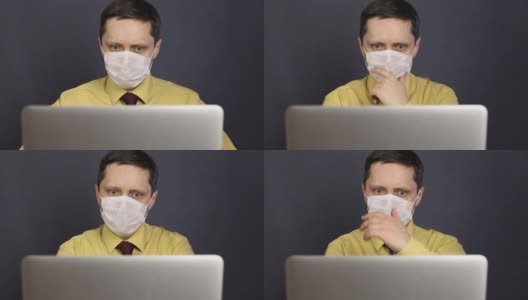 一名戴着医用口罩的男子通过互联网在笔记本电脑上阅读新闻。他摸着下巴，乱作手势。他沮丧地摇了摇头。冠状病毒疫情期间的自我隔离。高清在线视频素材下载