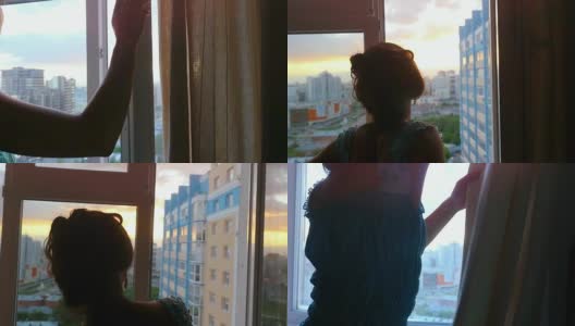 年轻女子拉开窗帘，在美丽的夕阳下从窗口俯视城市高清在线视频素材下载