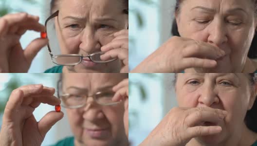 一位年长女性服用红色药片的特写高清在线视频素材下载