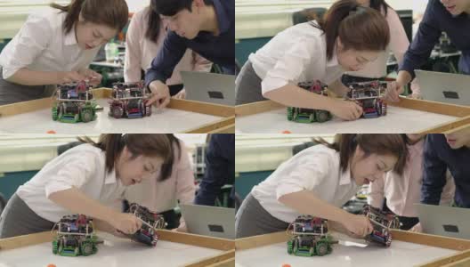 亚洲青少年年轻工程师组装和测试机器人手臂反应在实验室。建筑师设计电路，会议共享技术理念和协作开发机器人。高清在线视频素材下载