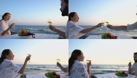 一对迷人的夫妇在海边享用美酒和水果，享受彼此的陪伴高清在线视频素材下载