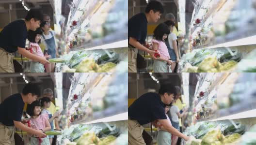 一个亚洲华人家庭周末在超市的冷藏区购买蔬菜高清在线视频素材下载