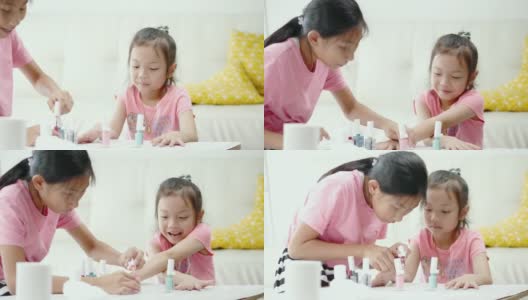 快乐的亚洲儿童涂指甲油，同时放松在一个家，生活理念。高清在线视频素材下载