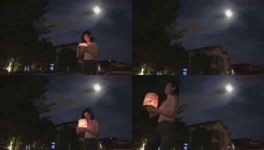 亚洲华人妇女手持纸灯笼行走，庆祝中秋节。高清在线视频素材下载