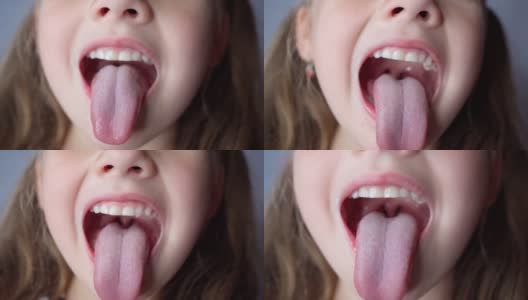 女孩张大嘴巴，伸出长长的舌头。孩子露出柔软的牙齿高清在线视频素材下载