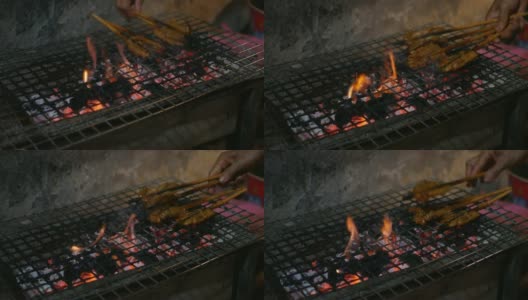 街头小吃摊贩在夜市准备和出售烤猪肉串，烧烤炸猪肉。Closeup.4k高清在线视频素材下载