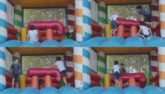 在公园里，孩子们在彩色的蹦床上蹦蹦跳跳高清在线视频素材下载