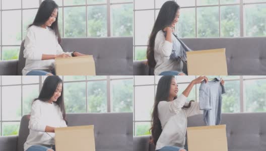 满意的亚洲女性顾客坐在沙发上打开网上订购购物快递包裹，开心的年轻女子打开包好购，送货上门的概念高清在线视频素材下载